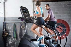 People climbing on Stairmasters at the gym